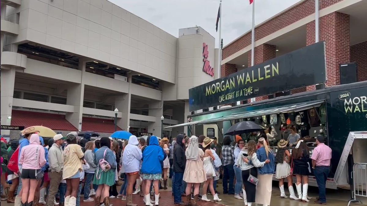 Fans stehen im Regen Schlange, um das Stadion beim Morgan-Wallen-Konzert zu betreten
