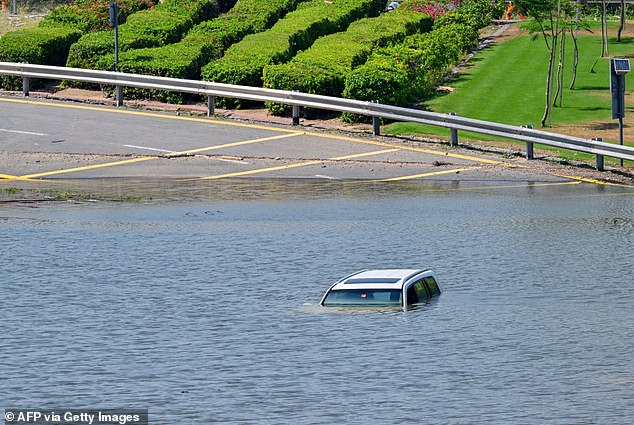 Nach heftigen Regenfällen am 18. April 2024 bleibt ein Auto auf einer überfluteten Straße in Dubai liegen