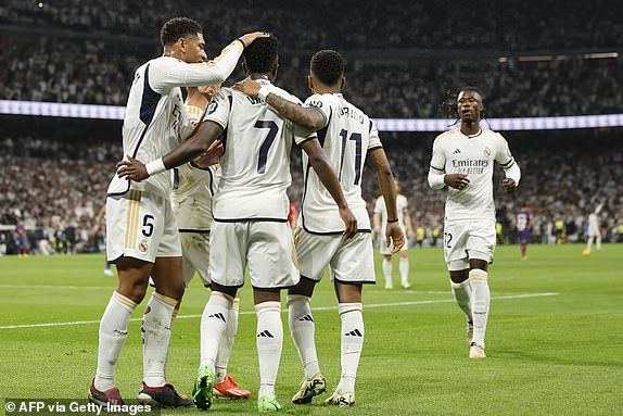 Real Madrid's Brazilian forward #07 Vinicius Junior celebrates with teammates scoring a goal from the penalty spot during the Spanish league football match between Real Madrid CF and FC Barcelona at the Santiago Bernabeu stadium in Madrid on April 21, 2024. (Photo by OSCAR DEL POZO / AFP) (Photo by OSCAR DEL POZO/AFP via Getty Images)