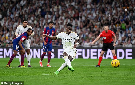 MADRID, SPAIN - APRIL 21: Vinicius Junior of Real Madrid scores his team's first goal from the penalty spot during the LaLiga EA Sports match between Real Madrid CF and FC Barcelona at Estadio Santiago Bernabeu on April 21, 2024 in Madrid, Spain. (Photo by David Ramos/Getty Images)