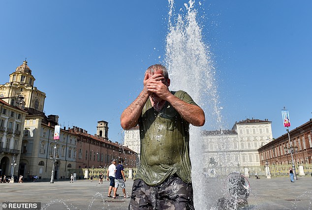 Europa erlebte im vergangenen Jahr großflächige Überschwemmungen und schwere Hitzewellen.  Hier kühlt sich ein Mann während einer Hitzewelle in Turin, Italien, am 25. August 2023 in der Nähe eines Brunnens auf der Piazza Castello ab