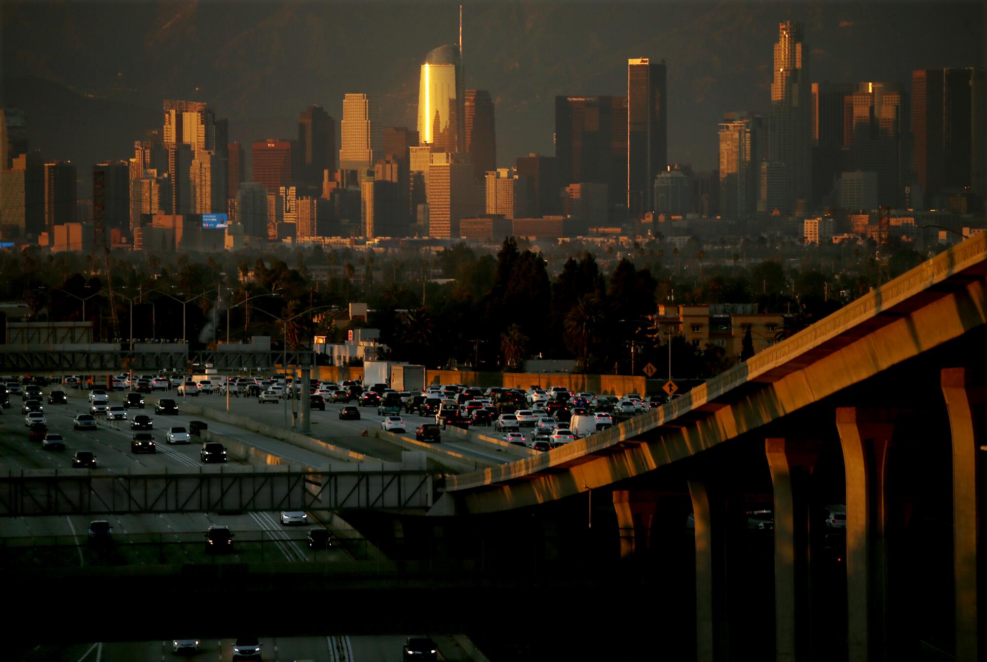 Ein smogiger Himmel mit der Skyline der Innenstadt von Los Angeles und einer Autobahn voller Autos