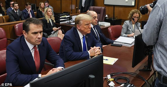 epa11293957 Former US President and current Republican presidential candidate Donald Trump (C) sits in the courtroom at Manhattan Criminal Court in New York, New York, USA, 22 April 2024. Trump is facing 34 felony counts of falsifying business records related to payments made to adult film star Stormy Daniels during his 2016 presidential campaign.  EPA/BRENDAN MCDERMID / POOL