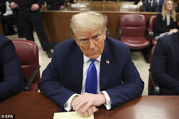 epa11293937 Former US President and current Republican presidential candidate Donald Trump looks on as he awaits the start of proceedings at Manhattan Criminal Court in New York, New York, USA, 22 April 2024. Trump is facing 34 felony counts of falsifying business records related to payments made to adult film star Stormy Daniels during his 2016 presidential campaign.  EPA/YUKI IWAMURA / POOL