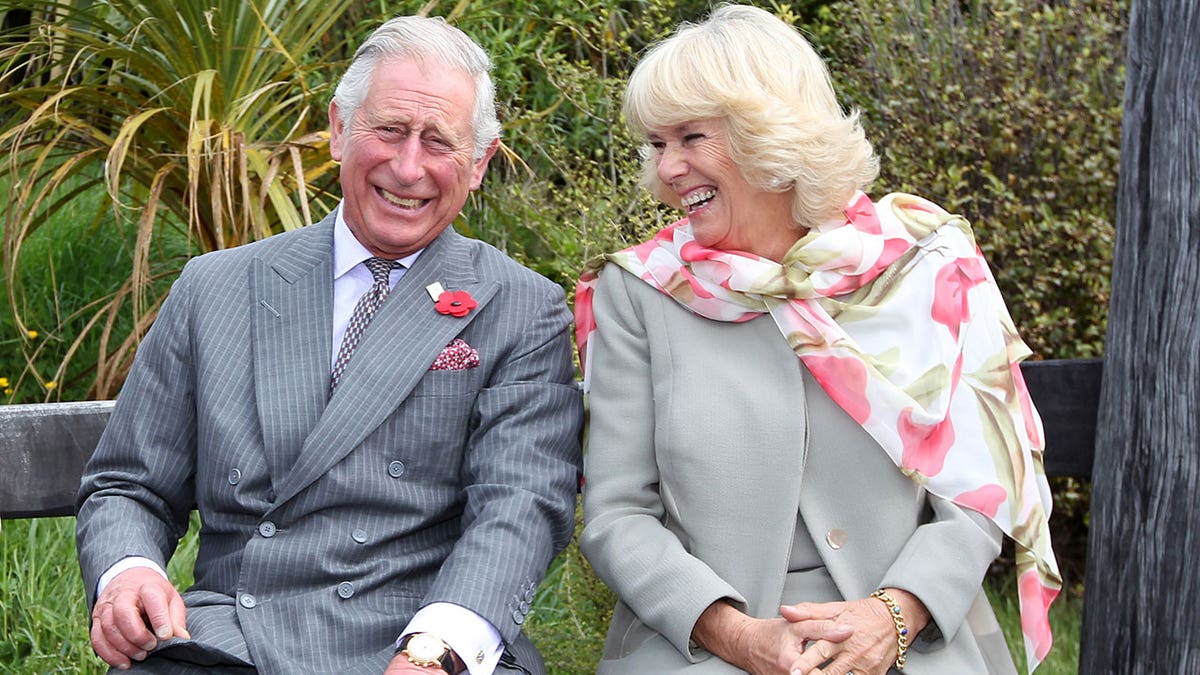 König Charles lacht mit seiner Frau Camilla
