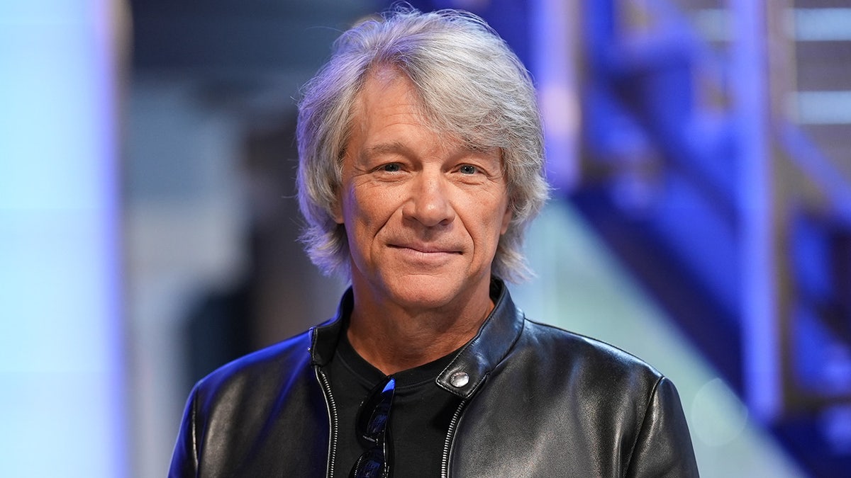 Jon Bon Jovi lächelt sanft und blickt in einer Lederjacke direkt in die Kamera