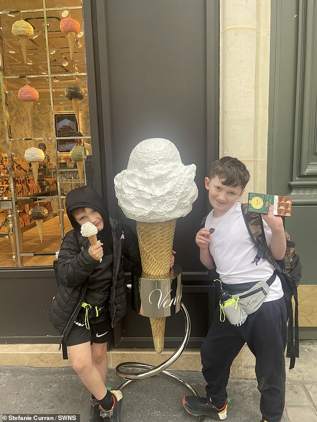 Die beiden Jungen sahen fröhlich aus, als sie neben einer Eistüte mit einem Schokoladengenuss fotografiert wurden