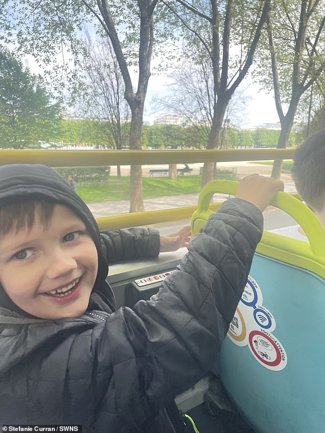 Romeo, 7, genießt die Aussicht auf Paris aus einem offenen Bus.  Die Familie reiste mit dem Sightseeing-Bus Tootbus quer durch die Stadt zum Gesamtpreis von 83 €