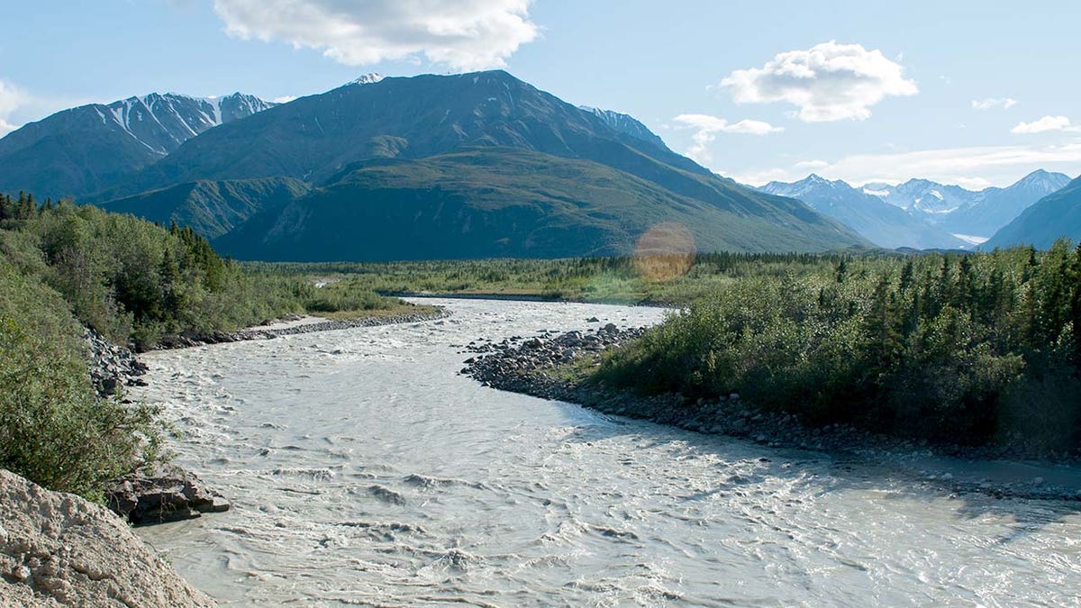 Ein Fluss in Alaska mit einem Berg im Hintergrund während des Tages