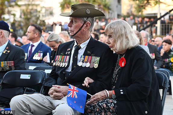epa11298808 A veteran (L) attends Anzac Day Dawn Service at Elephant Rock in Currumbin on the Gold Coast, Australia, 25 April 2024. Thousands of Australians will gather to commemorate the contribution of Australian defence personnel in wars, conflicts, and peacekeeping operations at Anzac Day services across the country. Anzac Day is observed on 25 April annually.  EPA/JONO SEARLE AUSTRALIA AND NEW ZEALAND OUT