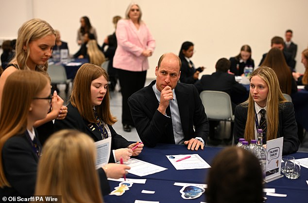 The Prince of Wales looks deep in thought as he speaks with students using the 'Talking Tables' initiative today