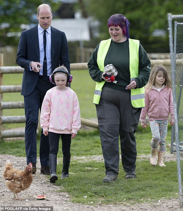 William points to a chicken as he visits a city farm in Birmingham today that supports children and young people