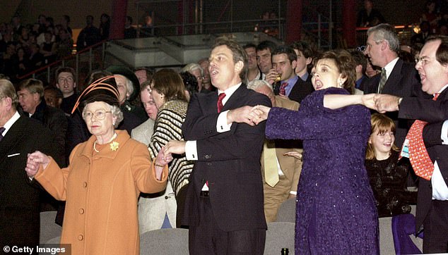 Königin Elizabeth II., der britische Premierminister Tony Blair und seine Frau Cherie Blair reichen 1999 für Auld Lang Syne die Hände