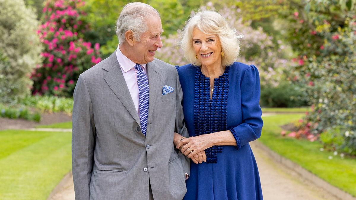Der britische König Karl III. und Königin Camilla stehen in den Gärten des Buckingham Palace