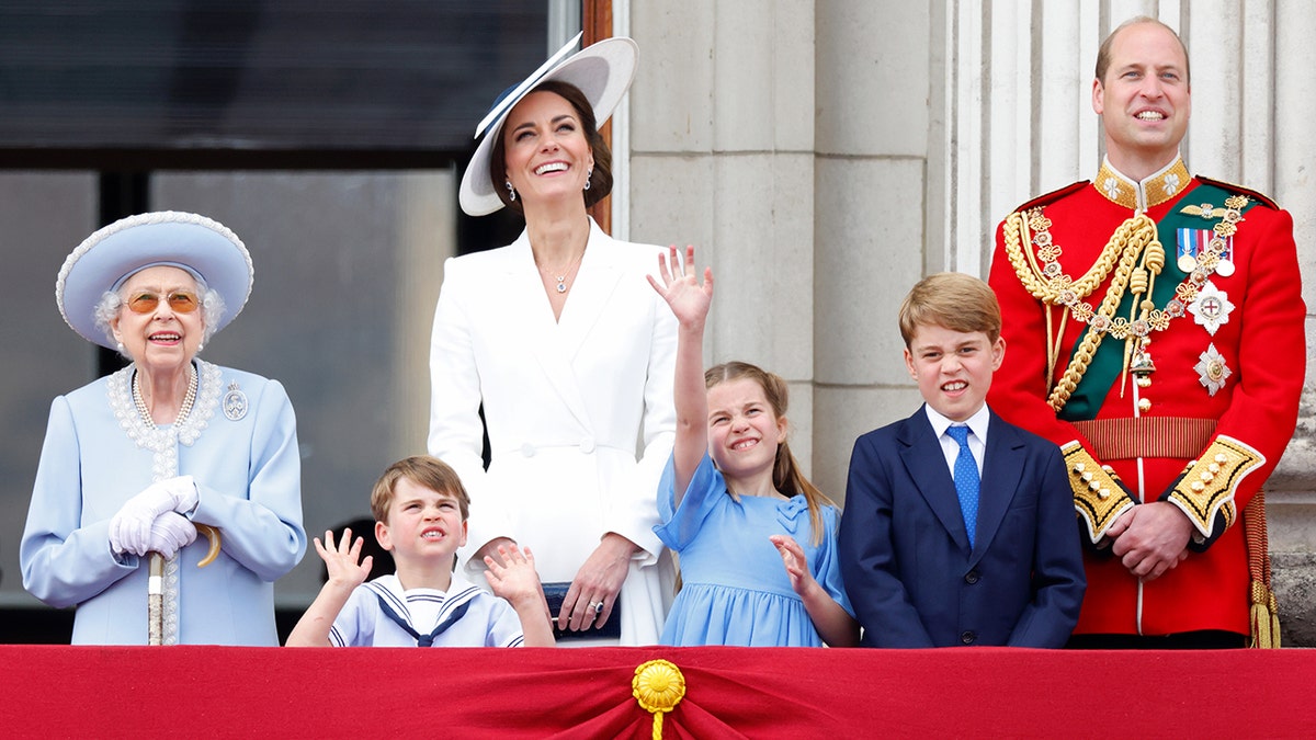 Prinz und Prinzessin von Wales auf dem Balkon des Palastes mit ihren Kindern neben einer lächelnden Königin Elisabeth