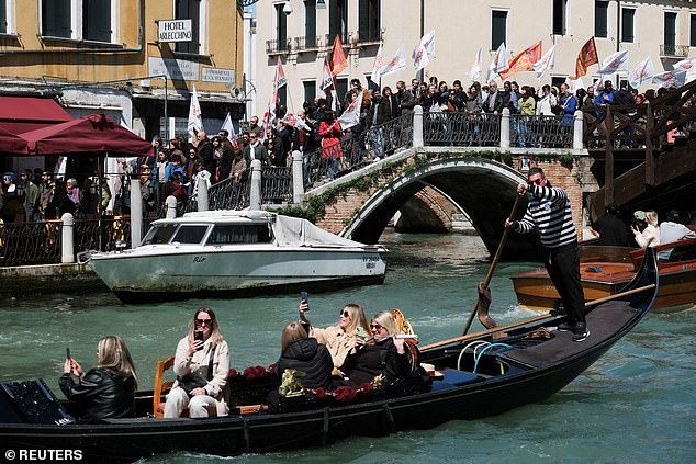 Menschen mit Transparenten protestieren gegen die Einführung der Zugangsgebühr in Venedig