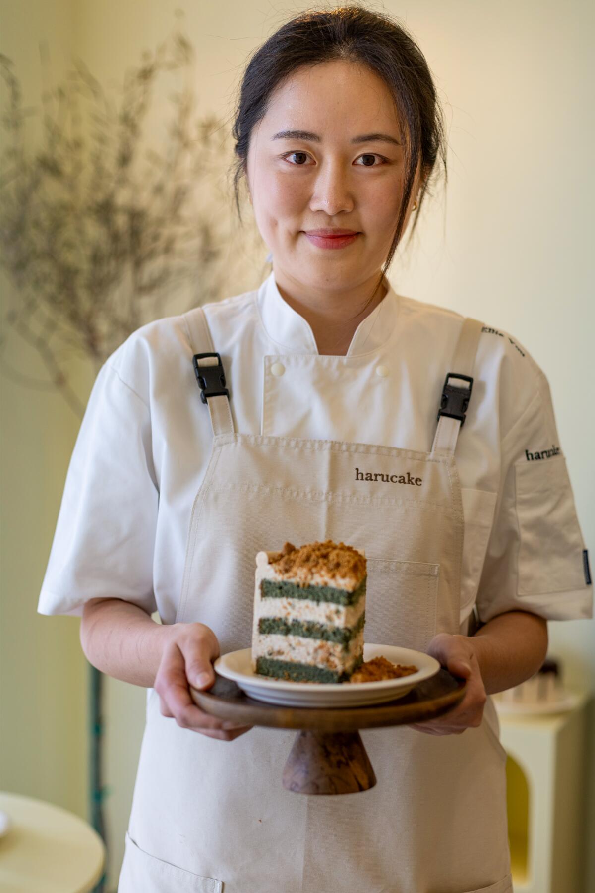 Ellie You, Besitzerin von Harucake, hält ein Stück Beifuß-Injeolmi-Kuchen in der Hand.