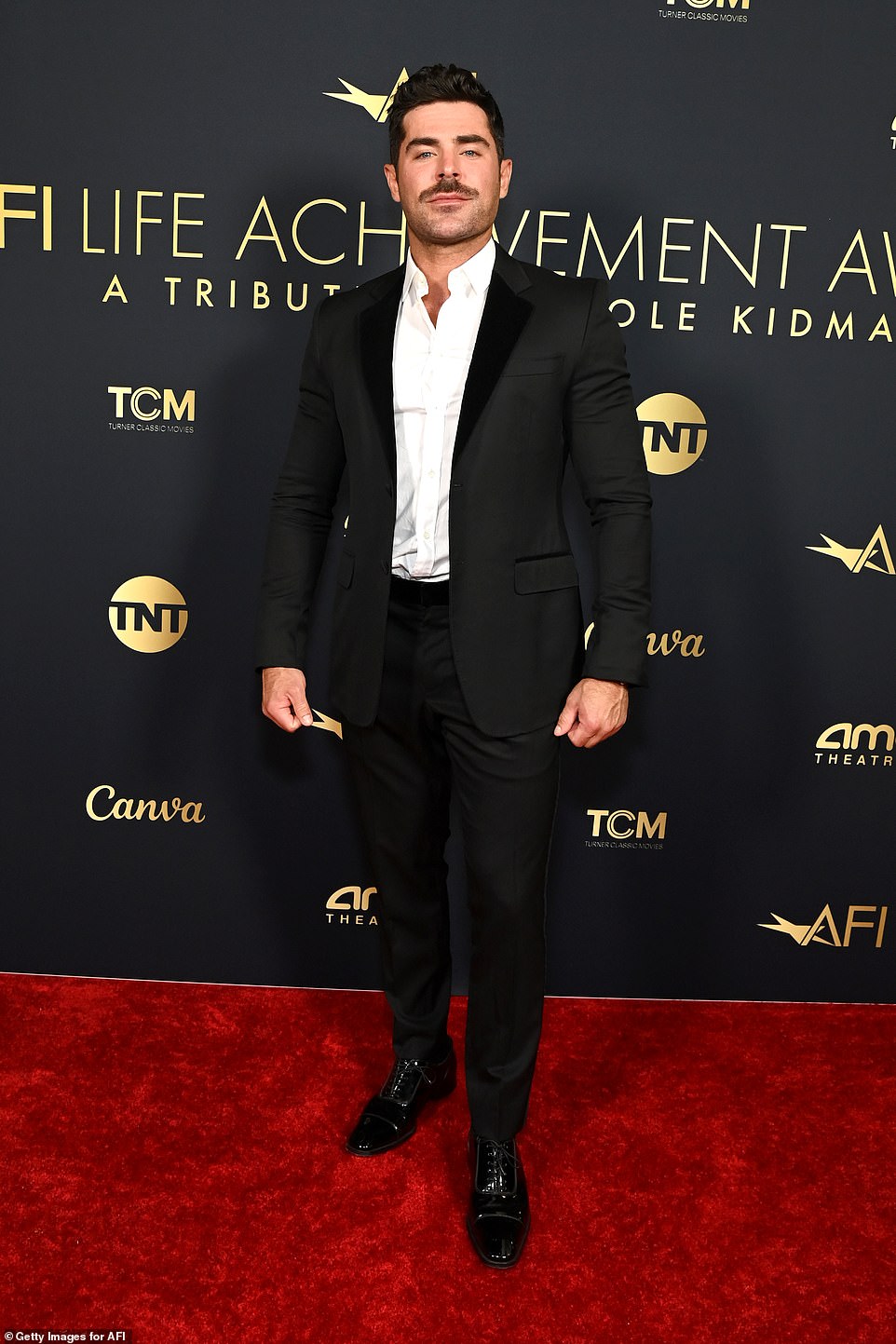 Efron was dapper in a classic black suit as well as a white dress shirt and sleek black dress shoes