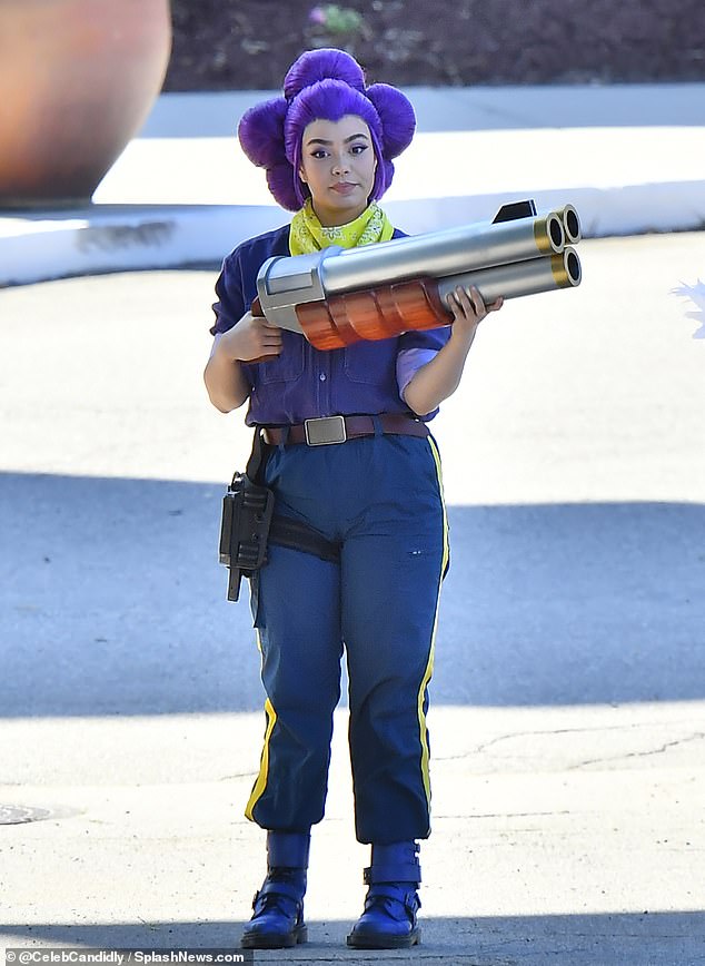 Fighting beside the Arrested Development alum was Mean Girls actress Auli'i Cravalho dressed as a massive gun-wielding character with a daisy-shaped bun on her purple wig