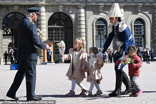 Junge Mädchen überreichen dem König heute Blumensträuße vor dem Schloss in Stockholm