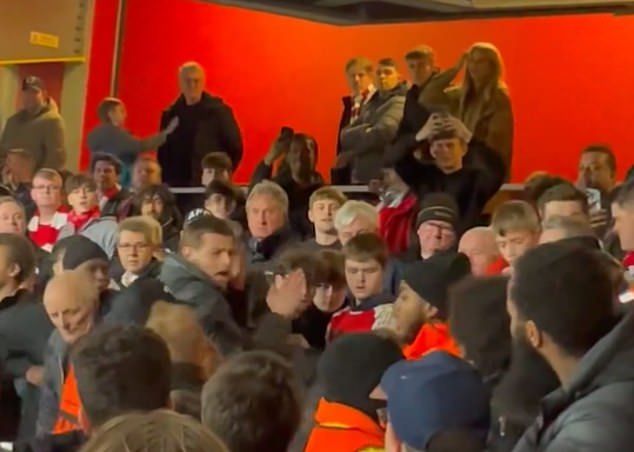 Arsenal-Fans schlugen abwechselnd auf einen Bayern-München-Fan ein, der in die Emirate eingedrungen war (links in der Mitte, grauer Mantel).