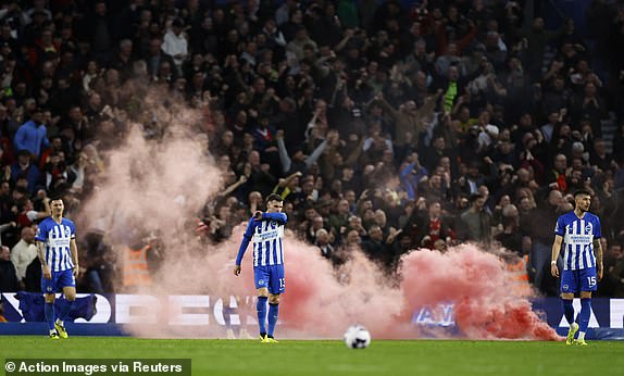 Soccer Football - Premier League - Brighton & Hove Albion v Arsenal - The American Express Community Stadium, Brighton, Britain - April 6, 2024 A smoke flare is thrown on the pitch as Brighton & Hove Albion players look dejected after Arsenal's Kai Havertz scores their second goal Action Images via Reuters/Peter Cziborra NO USE WITH UNAUTHORIZED AUDIO, VIDEO, DATA, FIXTURE LISTS, CLUB/LEAGUE LOGOS OR 'LIVE' SERVICES. ONLINE IN-MATCH USE LIMITED TO 45 IMAGES, NO VIDEO EMULATION. NO USE IN BETTING, GAMES OR SINGLE CLUB/LEAGUE/PLAYER PUBLICATIONS.