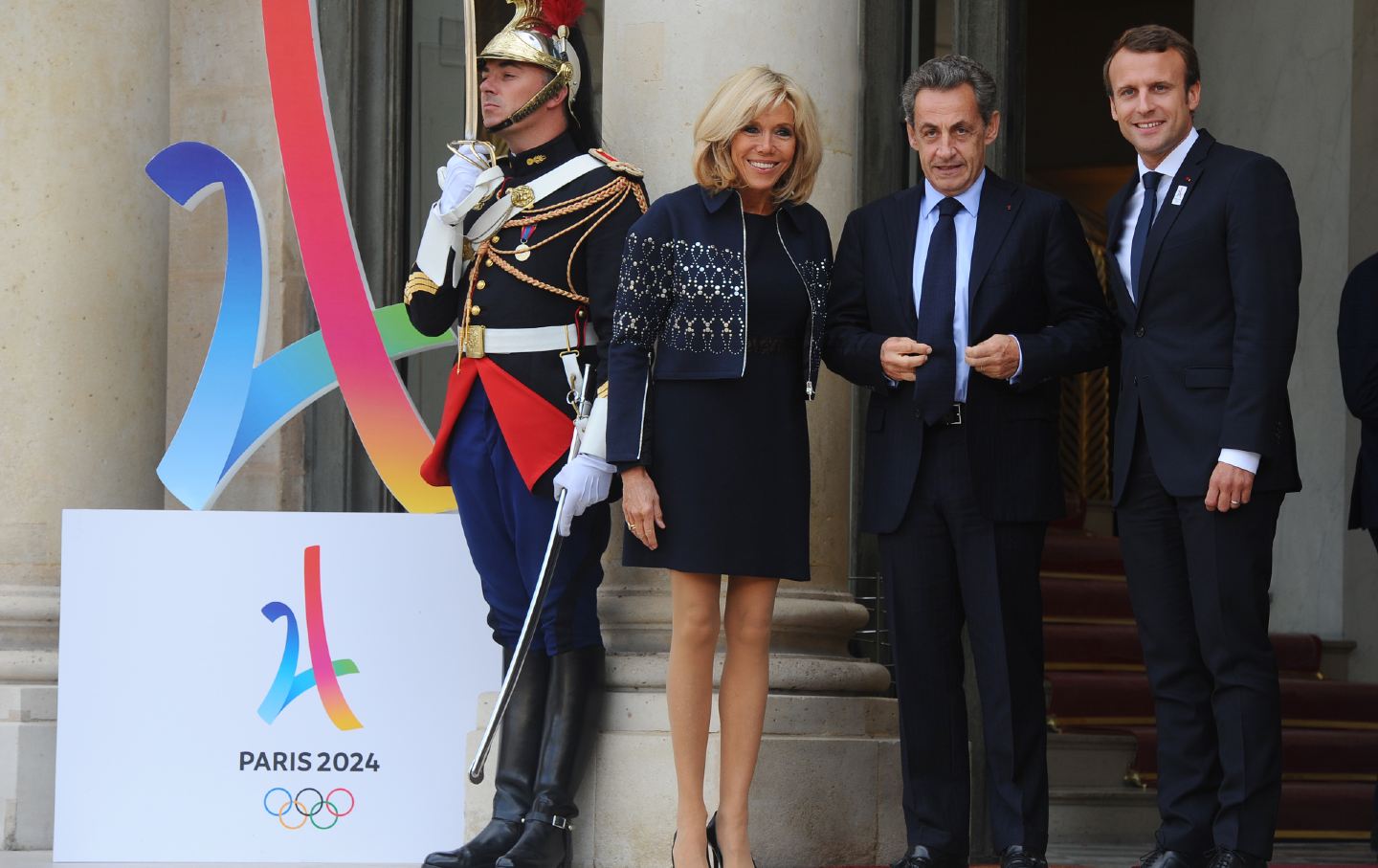 Macron und Sarkozy neben Olympia-Schild