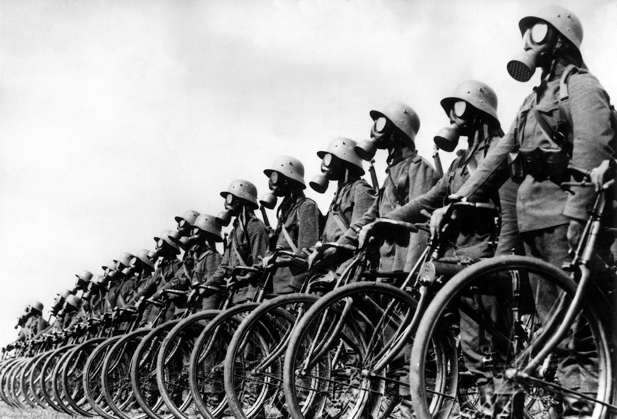 Mitglieder des deutschen leichten Maschinengewehr-Fahrradkorps tragen Gasmasken, während sie neben ihren Fahrrädern stehen
