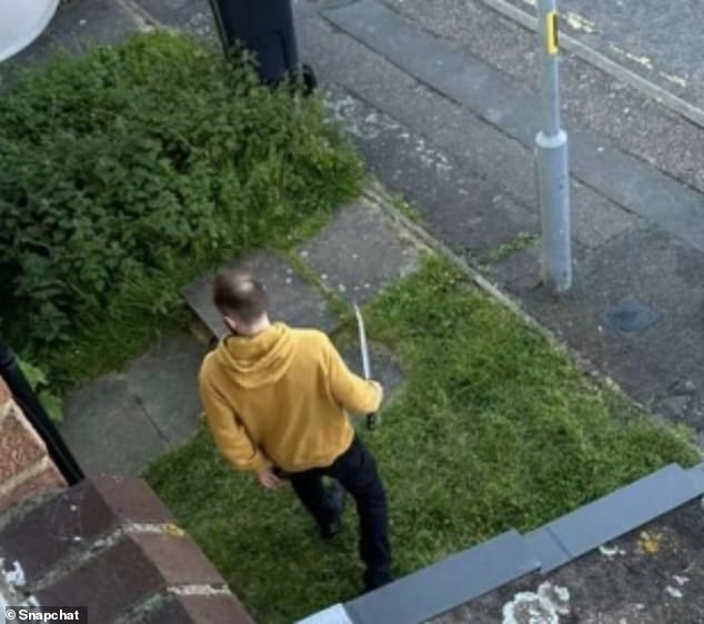 In den sozialen Medien veröffentlichtes Filmmaterial scheint einen Schwertkämpfer zu zeigen, der einen gelben Kapuzenpullover trägt und von Beamten angesprochen wird
