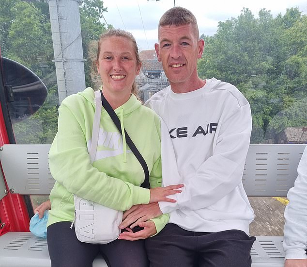Mark Downey, 45, aus Bolton, Manchester, abgebildet mit seiner Partnerin Samantha Scott, 39, wurde im September 2023 von quälenden Kopfschmerzen heimgesucht, als er mit seiner Familie zu einem Urlaub in Wales fuhr