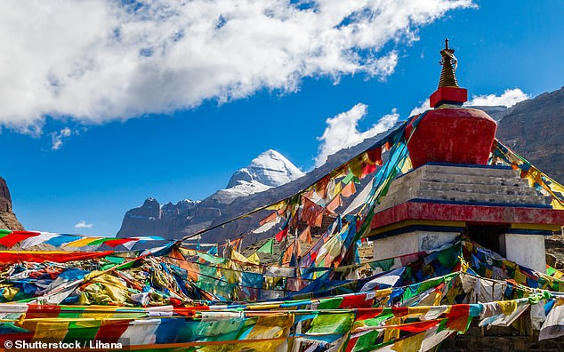 Bunte Gebetsfahnen flattern im Wind, im Hintergrund die Südwand des Mount Kailash