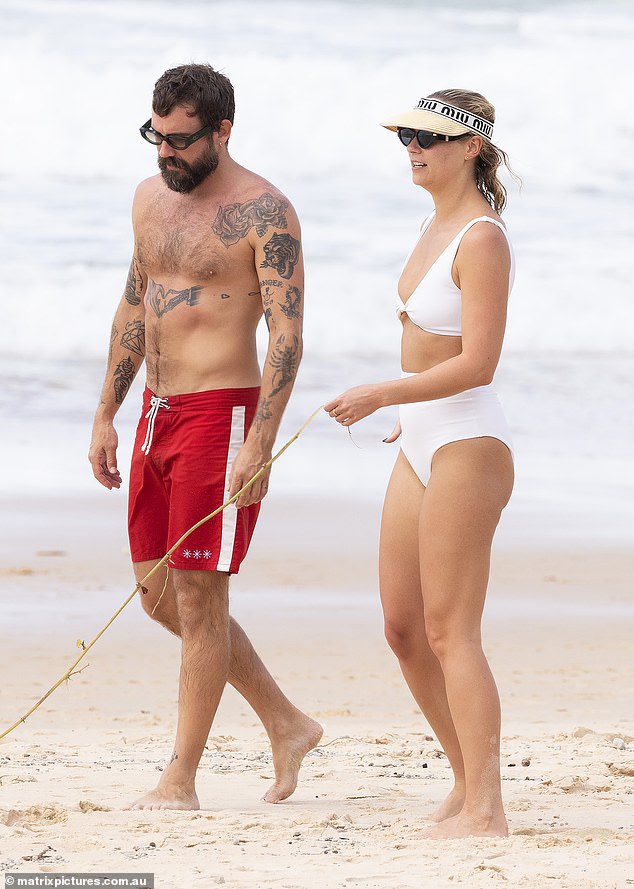 Am Freitag strahlte die frischgebackene, 32-jährige Blondine, als sie mit ihrem neuen männlichen Kumpel, dem Modedesigner Matty Bouris (links), den Strand von Noosa, Queensland, betrat.