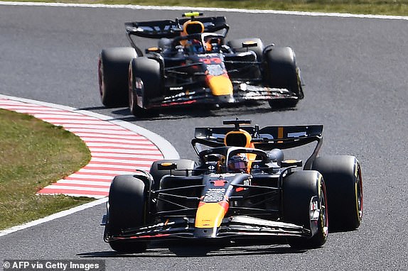 Red Bull Racing's Dutch driver Max Verstappen (front) takes a turn ahead of Red Bull Racing's Mexican driver Sergio Perez (behind) at the start of the Formula One Japanese Grand Prix race at the Suzuka circuit in Suzuka, Mie prefecture on April 7, 2024. (Photo by Toshifumi KITAMURA / AFP) (Photo by TOSHIFUMI KITAMURA/AFP via Getty Images)