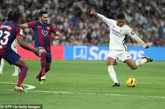 Real Madrid's English midfielder #5 Jude Bellingham (R) kicks the ball during the Spanish league football match between Real Madrid CF and FC Barcelona at the Santiago Bernabeu stadium in Madrid on April 21, 2024. (Photo by Thomas COEX / AFP) (Photo by THOMAS COEX/AFP via Getty Images)