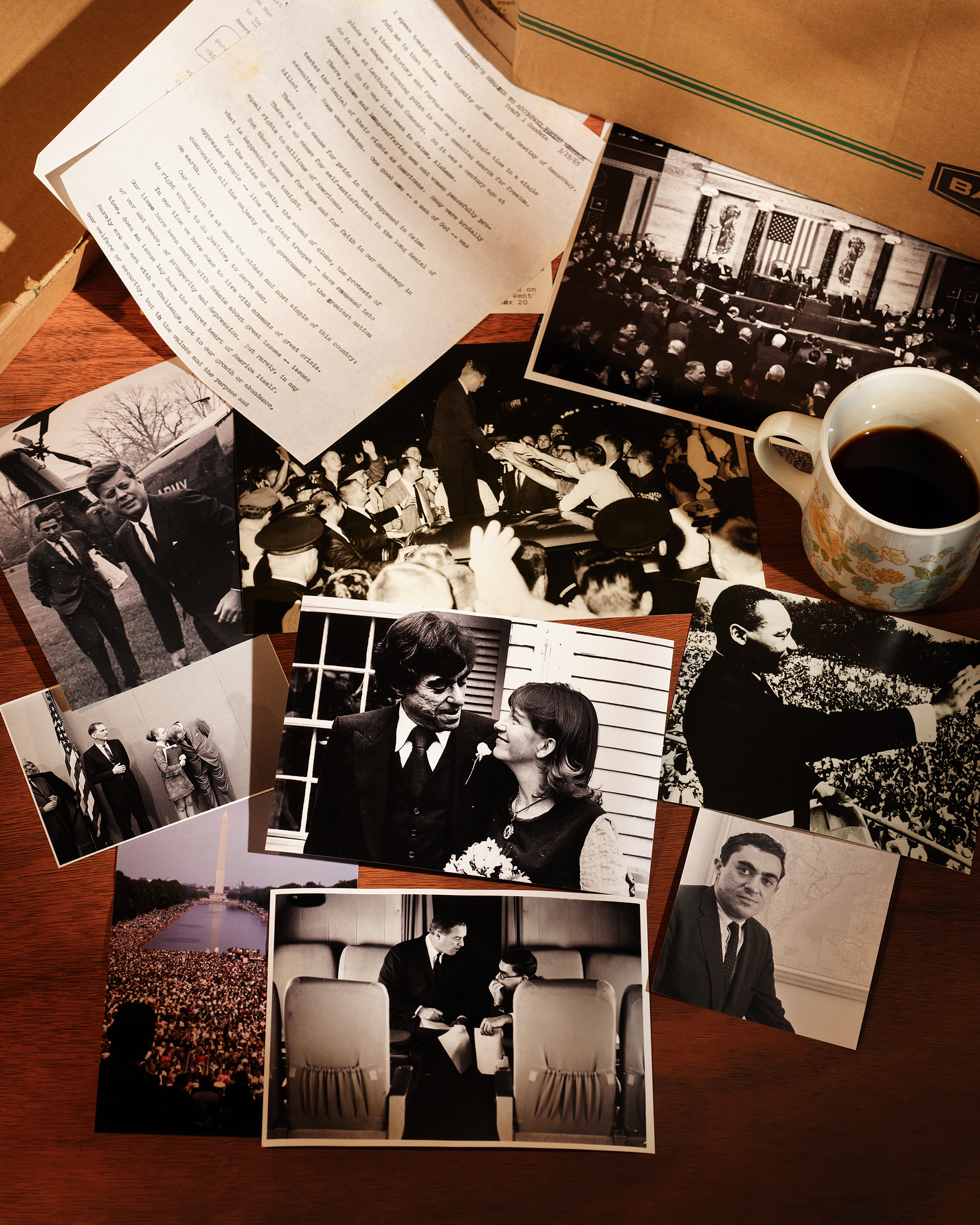 Mehrere alte Bilder und Dokumente neben einem braunen Karton und einer Tasse Kaffee