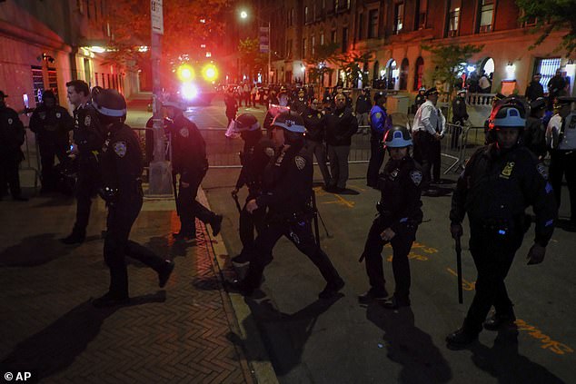 Members of the New York Police Department strategic response team move towards an entrance to Columbia University on April 30