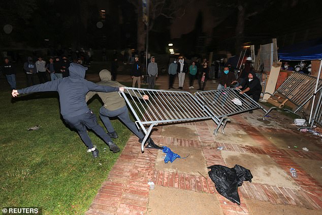 Counter-protesters try to remove barricades at the pro-Palestinian encampment on the University of California, Los Angeles