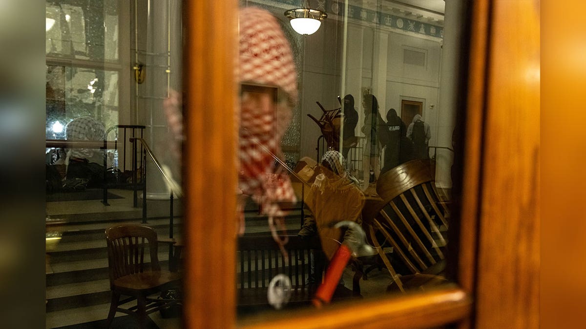 Demonstrant der Columbia University hält Hammer neben Türfenster