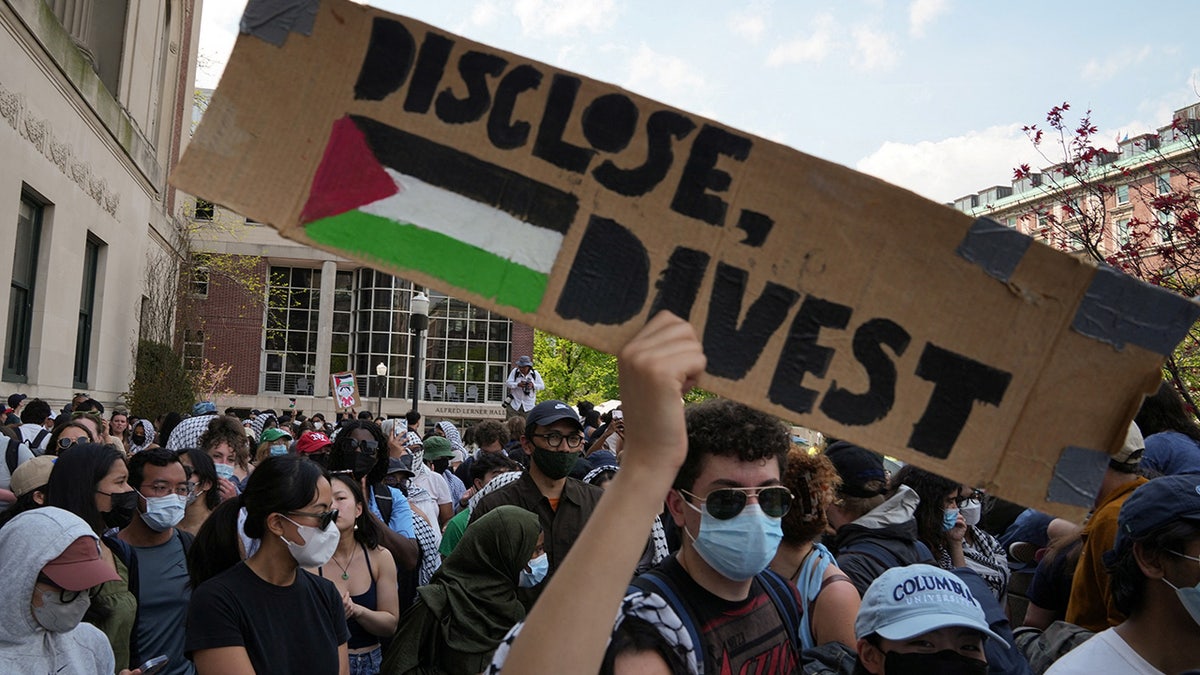Ein Demonstrant hält während eines Marsches auf dem Campus der Columbia University ein Schild zur Unterstützung eines Protestlagers zur Unterstützung der Palästinenser