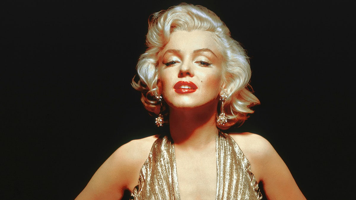 Eine Nahaufnahme von Marilyn Monroe in einem goldenen Neckholder-Kleid