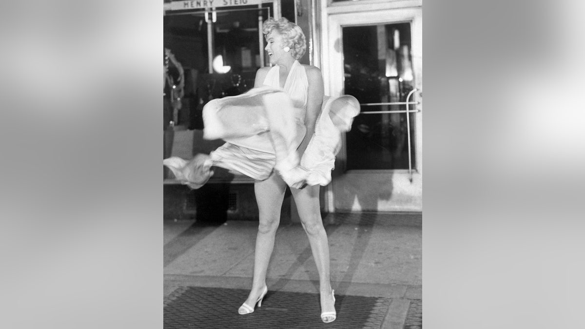 Marilyn Monroe versucht, ihr fließendes weißes Kleid festzuhalten