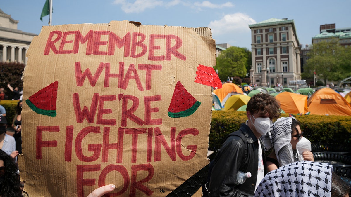 Ein Demonstrant hält während eines Marsches auf dem Campus der Columbia University ein Schild zur Unterstützung eines Protestlagers zur Unterstützung der Palästinenser
