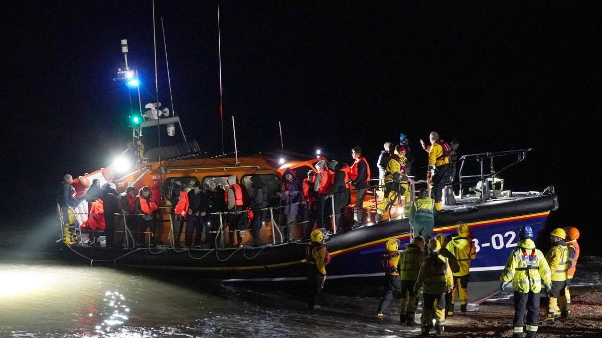 Ein Rettungsboot landet mit geretteten Migranten an Land