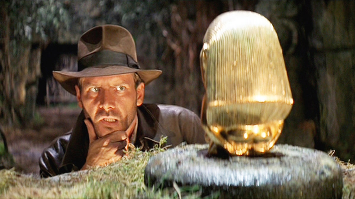 Harrison Ford als Indiana Jones betrachtet das Idol im ersten Film