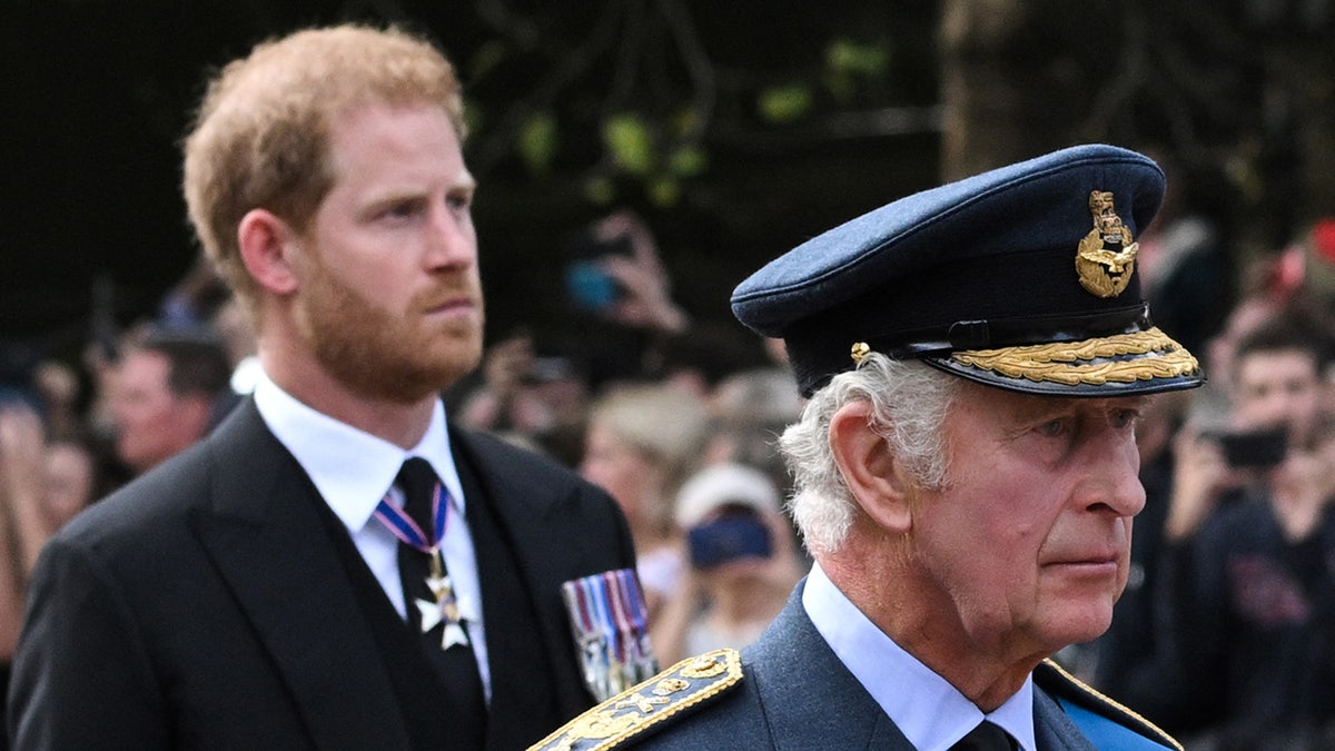 Prince Harry walking behind his father King Charles as they both look sorrowful