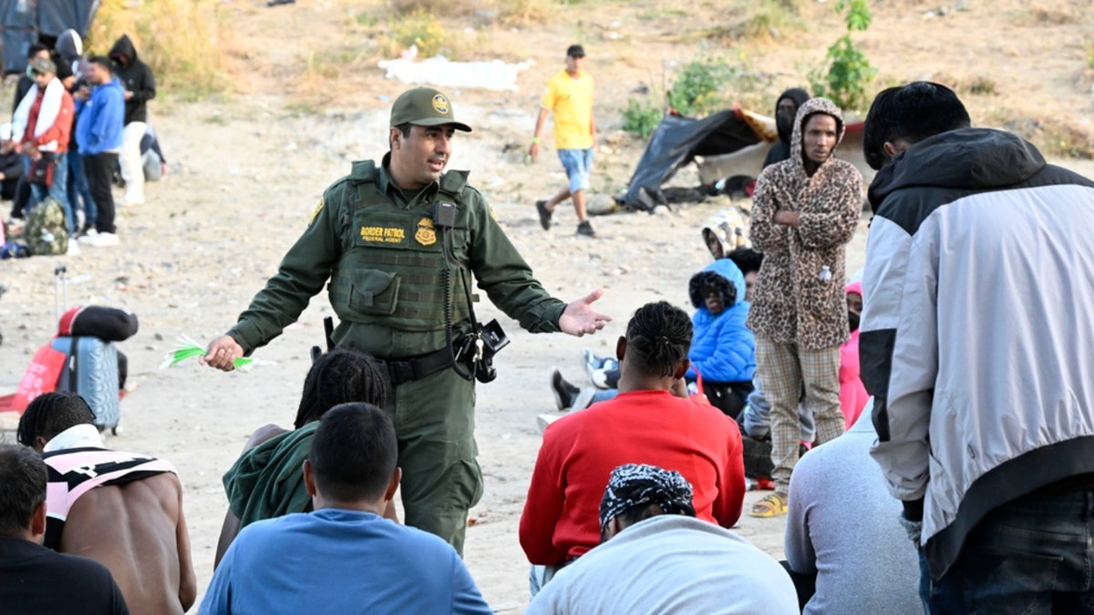 Ein US-Grenzschutzbeamter spricht mit Asylsuchenden