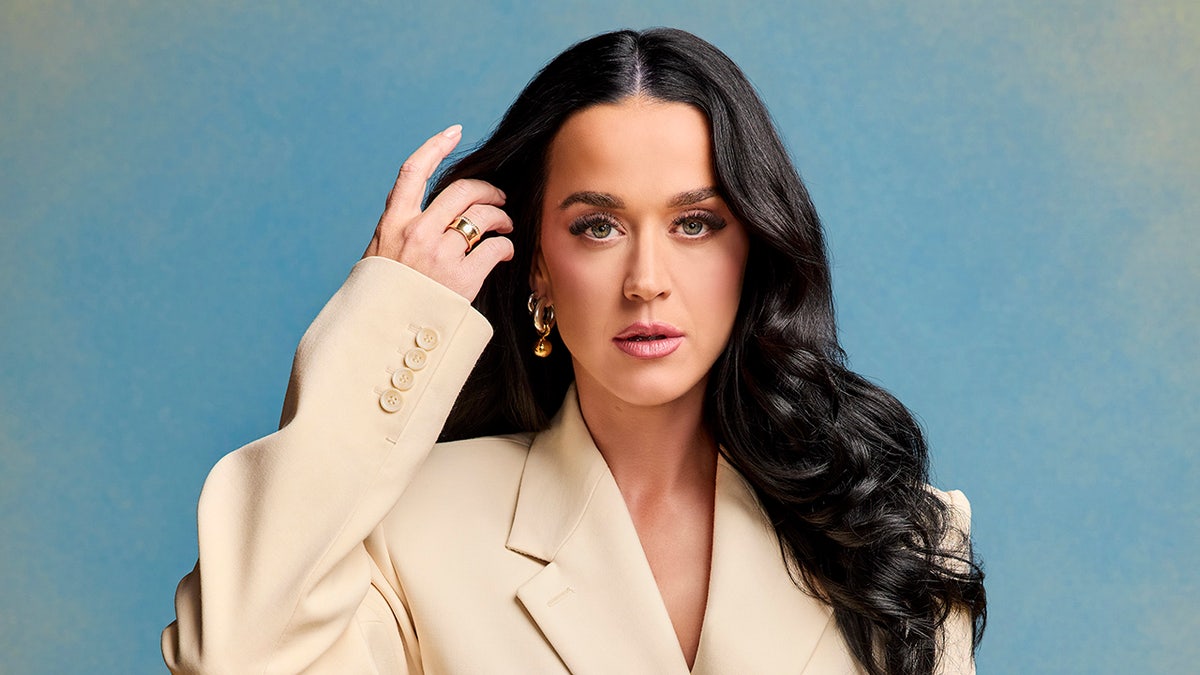 Katy Perry hebt in einer cremefarbenen Jacke ihre Finger an ihr Haar "amerikanisches Idol" schießen