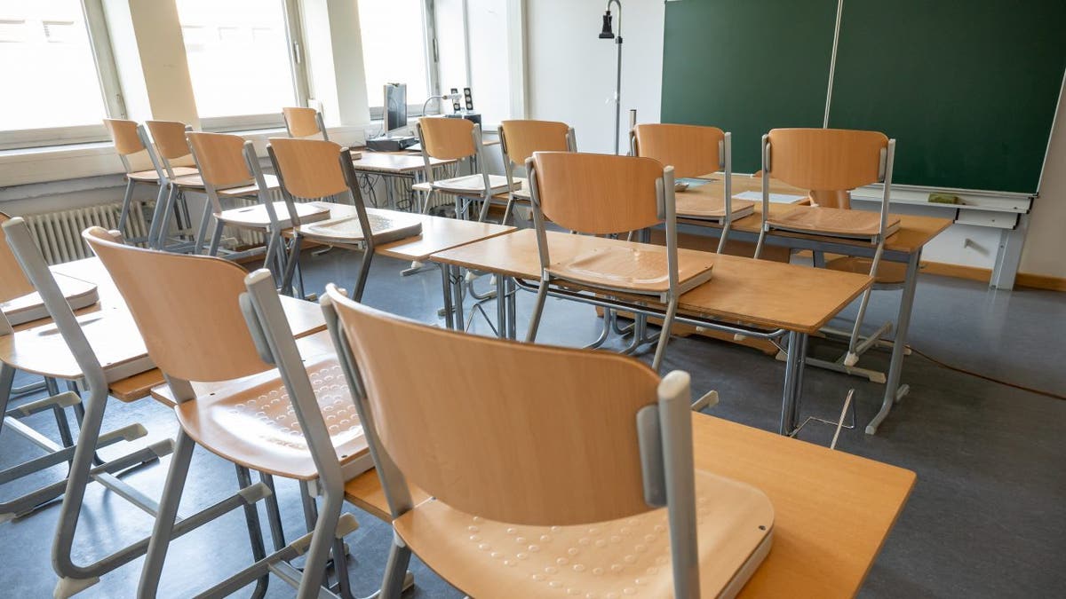 Ein leeres Klassenzimmer mit aufgestellten Stühlen.