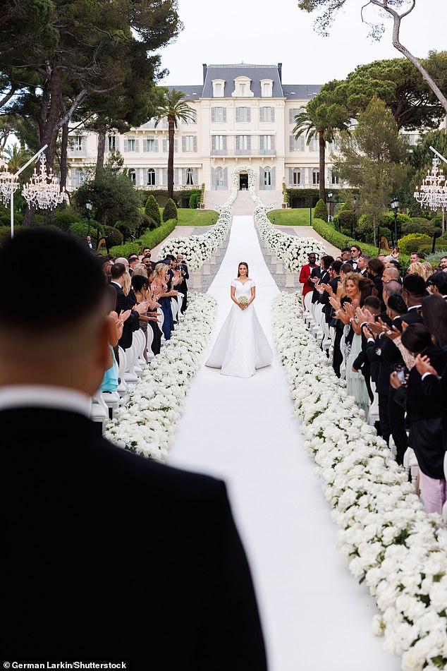 In the couple's first wedding ceremony, Nada had the aisle of dreams with a lengthy white carpet lined with flowers