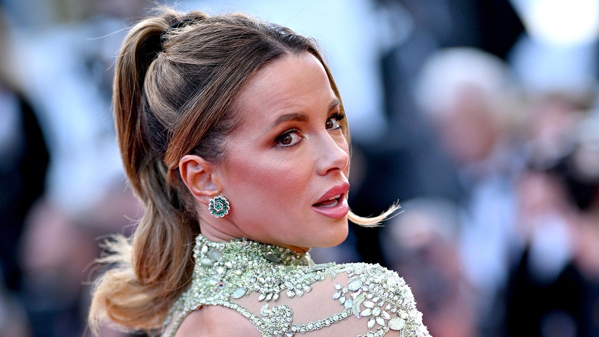 Kate Beckinsale blickt in Cannes in einem zarten hellgrünen Spitzenkleid über die Schulter